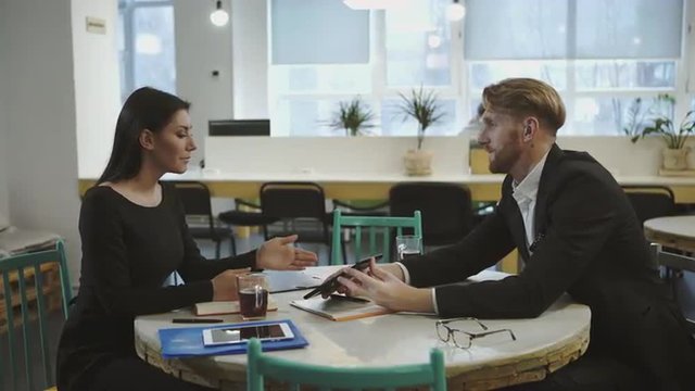 Business Partners at the meeting. Lady discusses strategy with a man.