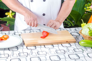 Chef cutting tomato