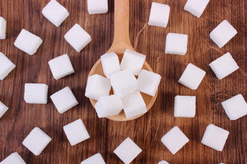 Cubes of sugar on wooden background, ingredient for cooking