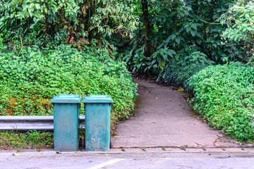 Obraz premium Green trashcan for keeping garbage in public park.