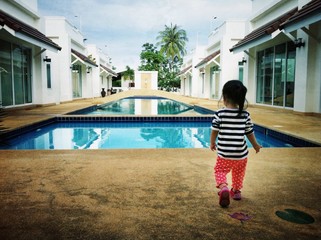 The girl is walking to the pool