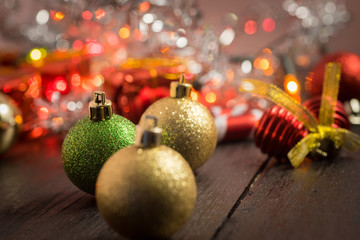 selective focus Christmas background with a red ornament, golden gift box, berries on black wood blackground still life