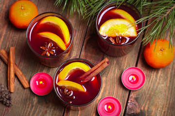 Christmas mulled wine in glasses with orange on wooden table, close up