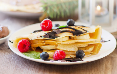 Christmas sweet breakfast. Crepes with chocolate cream and fresh