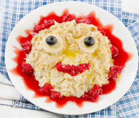 Smiling oatmeal and berries for a healthy breakfast.