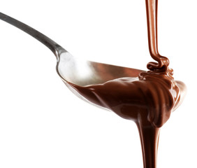 Melted milk chocolate pouring from a spoon, isolated on white