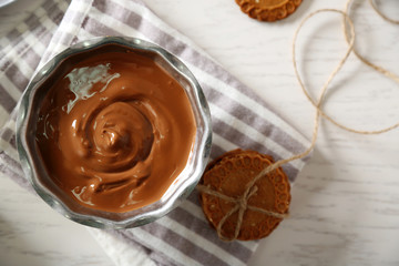 Melted chocolate in bowl, on wooden background