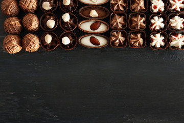 Delicious chocolate candies on blue wooden background