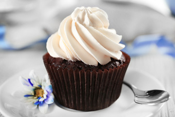 Delicious chocolate cupcake with cream on decorated wooden  table, close up