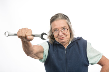 Seniorin mit Schraubenschlüssel ist entschlossen
