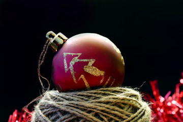 Red christmas globe on ball of thread on black
