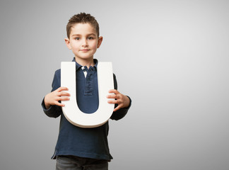 little kid holding a u letter © asierromero