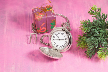 Pocket clock and gift box on pink background