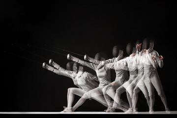 Full-length portrait of woman wearing white fencing costume  on black