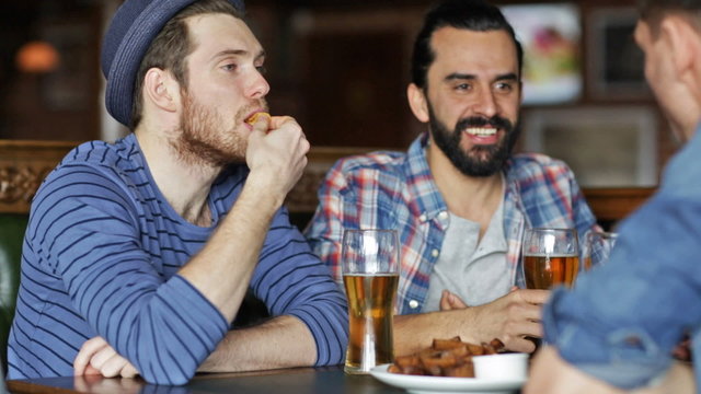 happy male friends drinking beer at bar or pub