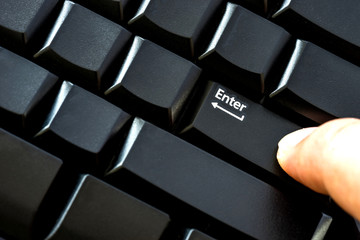 Finger pressing enter key close up