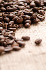 Coffee beans on table on sackcloth close up