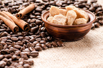 Coffee beans, cane sugar and cinnamon on the table