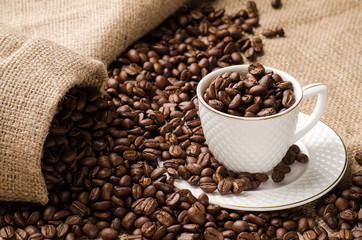 Coffee beans poured into the Cup and saucer and a bag of coffee