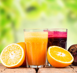 Fresh juices, orange, beetroot and carrot on wooden table 