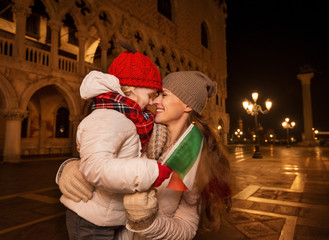 Fototapeta na wymiar Mother and child with Italian flag on Piazza San Marco in Venice