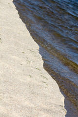 sand and water on the shore of a lake