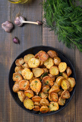 Fried potatoes in pan on wooden table