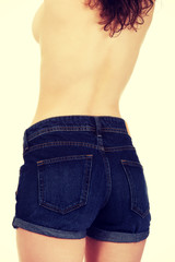 Shirtless woman in jeans shorts.