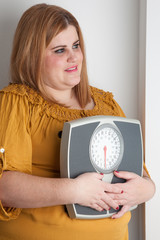 Smiling woman holding a bathroom scale