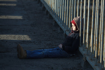 young homeless boy sleeping on the bridge