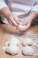 Fototapeta premium Woman's hands knead dough. Selective focus