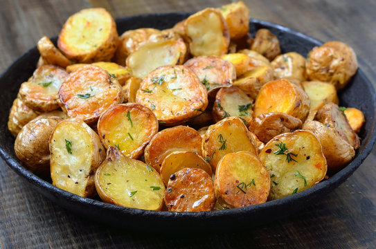 Fried potato in pan on wooden table
