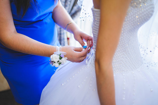 Bridesmaid Tying Bow on Dress