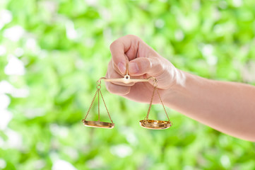 金色の天秤を持っている手