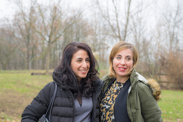 Fototapeta premium Two young women talking, smiling and having fun outdoors