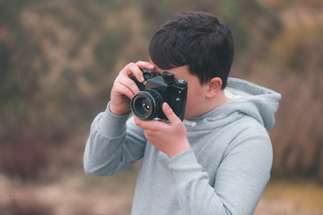 Young boy shooting with vintage camera