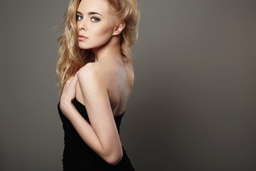 young beautiful woman in black dress.Sexy Blond girl.Curl Hairstyle