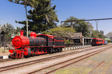 Steam Train locomotive coaches vintage monument alongside railway station