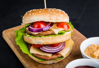 Big hamburger on kitchen board