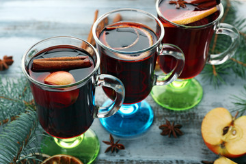 Tasty mulled wine and spices, on blue wooden background, close-up