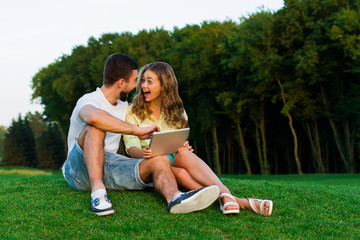 Gambling guy and girl playing games on a tablet.