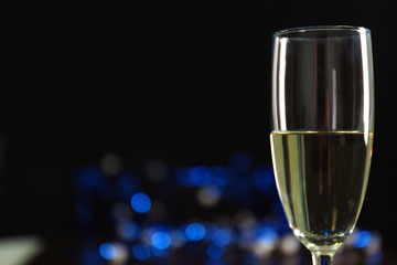 A glass of champagne with bokeh on dark background