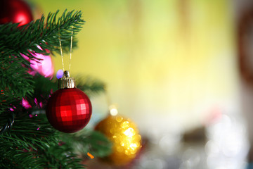 Christmas red bauble on a fir tree over blurred background