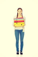 Teen woman holding binders.