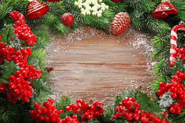 Fototapeta na wymiar Christmas fir tree branches with rowan and toys on wooden table