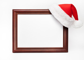 Fototapeta premium Wooden frame for paintings with a Christmas cap on a white background