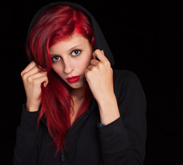 misterious woman with red hair covering her head with a hood