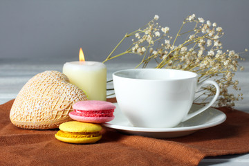 Decorative heart Valentine with a Cup and saucer on a napkin with cakes on wooden background