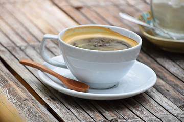 One full cup of Americano coffee on bamboo table