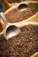Barrels of fresh coffee beans and scoop in gourmet specialty market